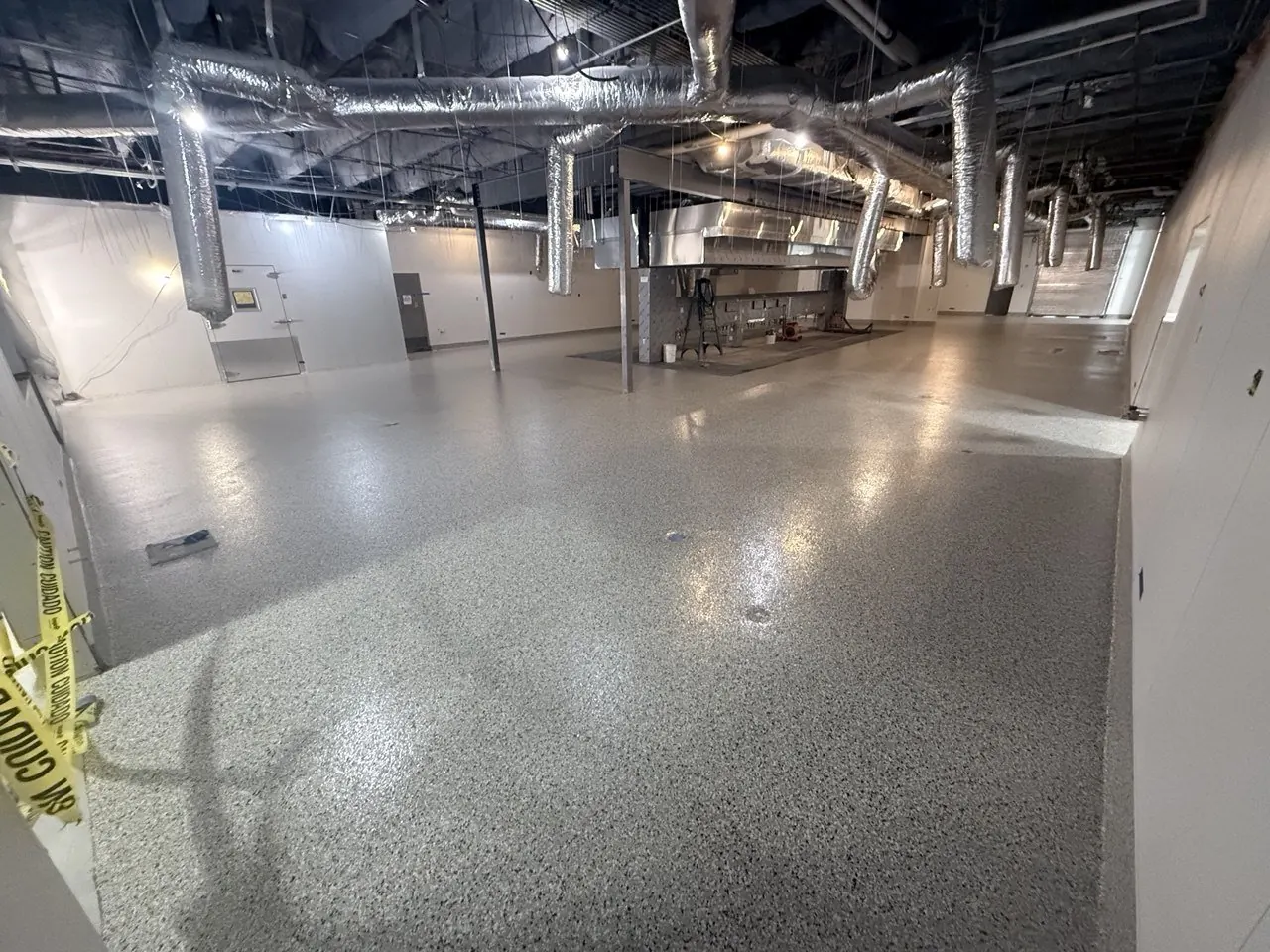 Commercial kitchen flake epoxy floor Naples FL — Installation with caution tape — work-in-progress, mid-broadcast phase