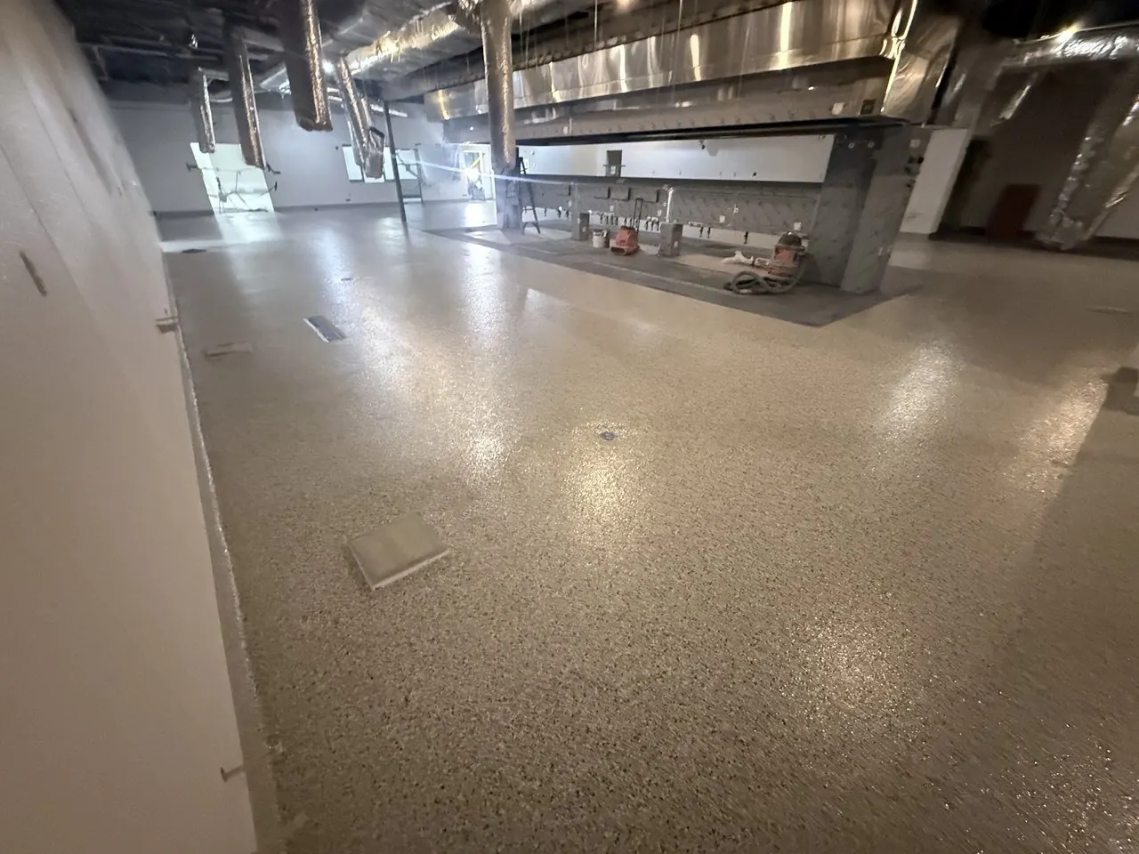 Commercial kitchen flake epoxy floor Naples FL — Prep line beneath stainless hood — hot zone